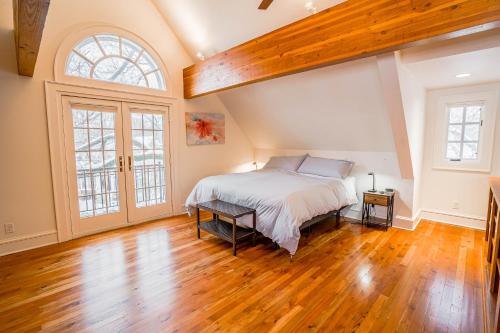 een slaapkamer met een groot bed en een houten vloer bij Kenilworth Place in Minneapolis