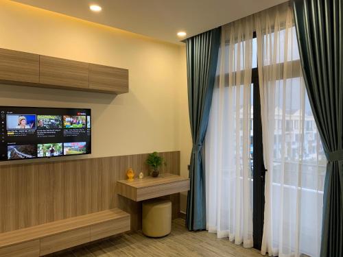 a room with a tv and a window with curtains at Liên’s Mini Hotel in Phu Quoc