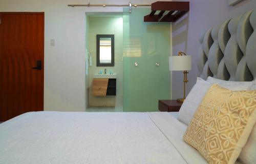 a bedroom with a bed and a bathroom with a sink at Victoria City Hotel in Oranjestad