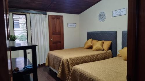 a room with two beds and a table and a window at AZURA HOTEL BOUTIQUE in Cobán