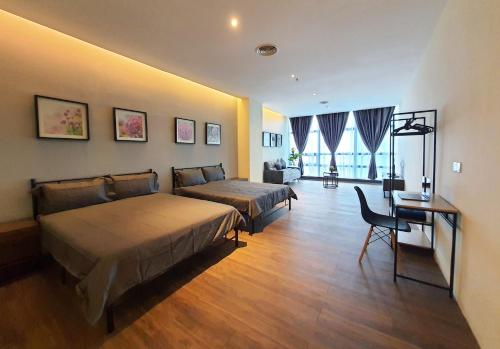 a bedroom with two beds and a desk and a couch at Bangsar Trade Centre Kuala Lumpur by SkyLimit Suites in Kuala Lumpur