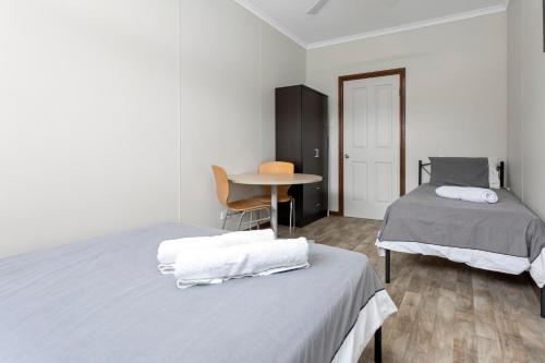 a bedroom with two beds and a table and a table at Beachside Escape on The Esplanade in Christies Beach