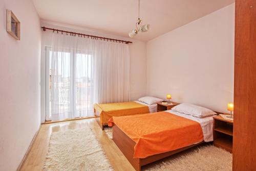 Duas camas num quarto com uma janela em Apartments by the sea Grebastica, Sibenik - 482 em Grebaštica