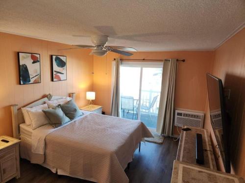 sypialnia z łóżkiem i wentylatorem sufitowym w obiekcie Beachfront Condo In Paradise w mieście Ocean City