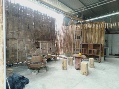 a room with wooden walls and wooden stumps in it at Homestay Tuấn Nghĩa - Hang Phượng Hoàng - Võ Nhai in Hoan Chung