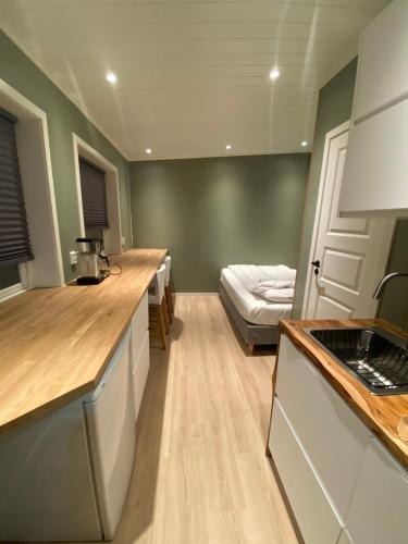 a kitchen with a sink and a bed in a room at Stave Camping & Hot Pools in Stave