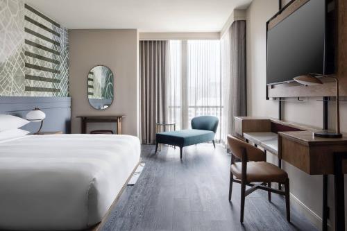 a hotel room with a bed and a desk at Marriott Dallas Uptown in Dallas