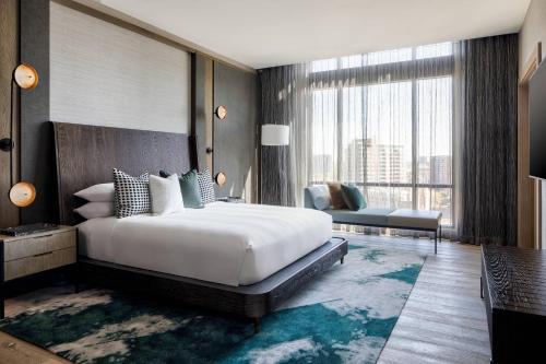 Marriott Dallas Uptown في دالاس: غرفة نوم بسرير كبير ونافذة كبيرة