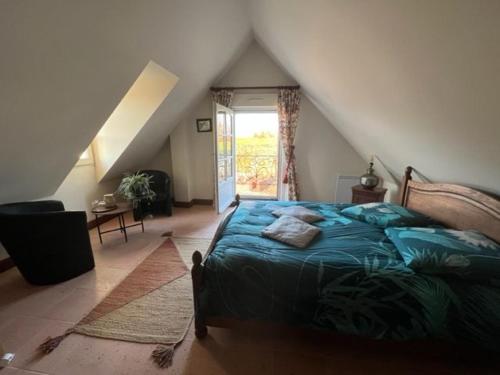 a bedroom with a bed and a staircase with a window at Retraite paisible avec cheminée, étang privé et chalet près du Mans - FR-1-410-382 in Dehault