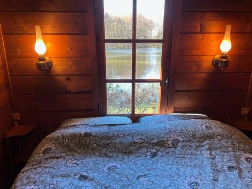 Chalet nature avec étang, terrasse et pêche No Kill - 2 chambres - FR-1-410-383 في Dehault: سرير في غرفة بها نافذة واضاءين