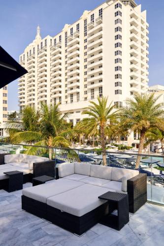 a large white building with palm trees in front of it at Loews Miami Beach Hotel in Miami Beach