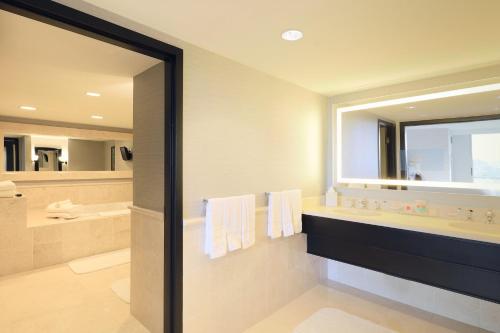 a bathroom with a tub and a large mirror at Loews Miami Beach Hotel in Miami Beach