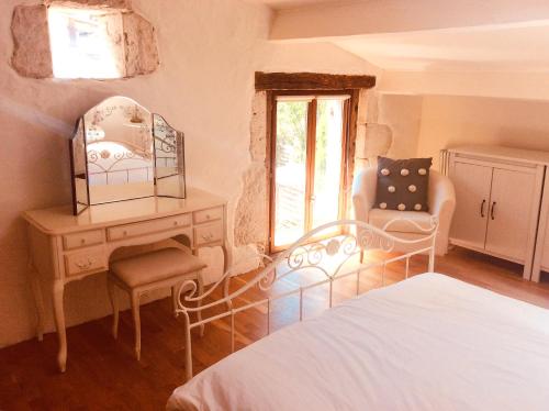 a bedroom with a bed and a desk and a chair at Maison de LOlivier, Beautiful Townhouse with Private courtyard in Eymet