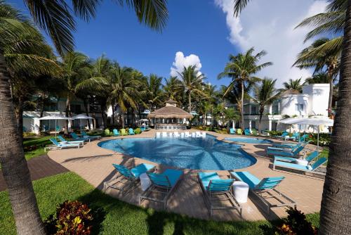 a swimming pool with blue chairs and palm trees at Margaritaville Island Reserve Riviera Cancún - An All-Inclusive Experience for All in Puerto Morelos