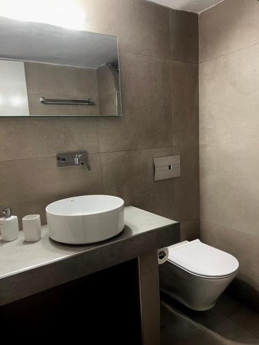 a bathroom with a sink and a toilet at Anna Maria Rooms Santorini in Perissa