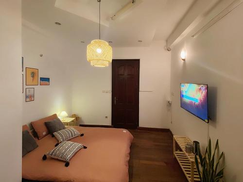 a bedroom with a large bed and a tv on the wall at Michi House Giang Văn Minh đối diện Bảo tàng HCM in Hanoi