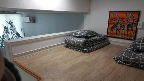 a living room with two ottomans and a mirror at Joa Guesthouse in Gwangju