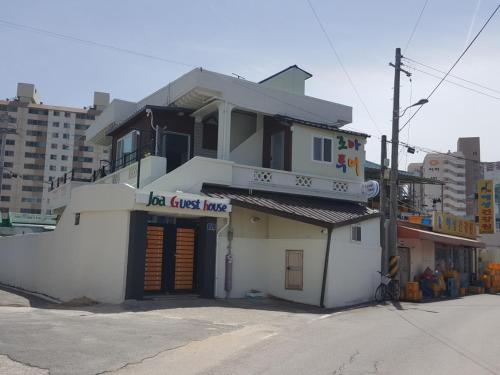 a white building with a sign that reads la guest house at Joa Guesthouse in Gwangju