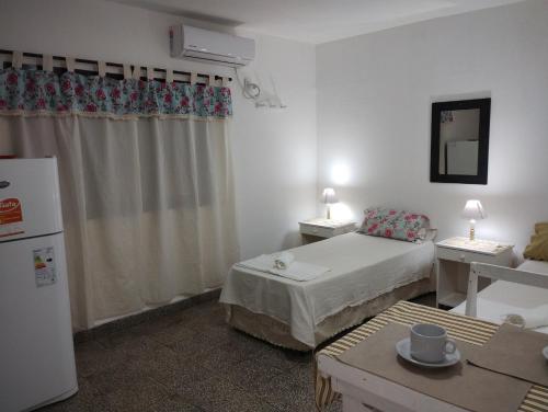 Habitación pequeña con cama y nevera. en Departamento Juana-Franch en Salta