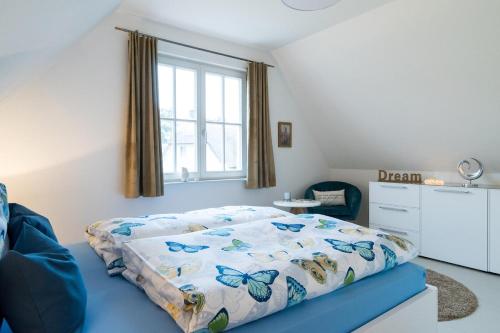 a bedroom with a bed with a butterfly comforter at Ferienhaus Greta in Glowe