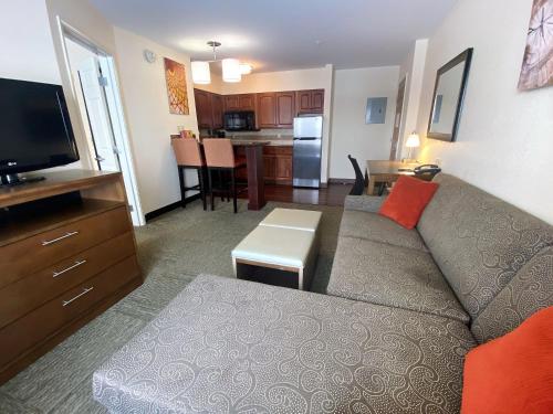 a living room with a couch and a kitchen at Staybridge Suites Great Falls by IHG in Great Falls