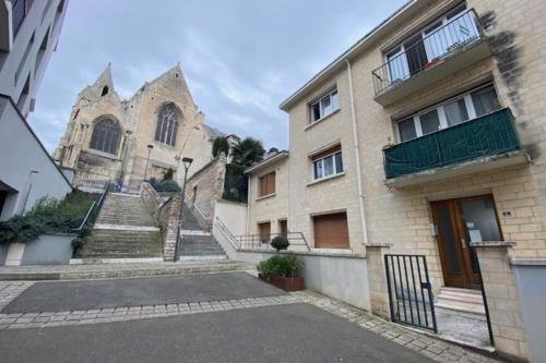 un ancien bâtiment avec des escaliers et une église dans l'établissement Charming 44m near downtown, à Caen