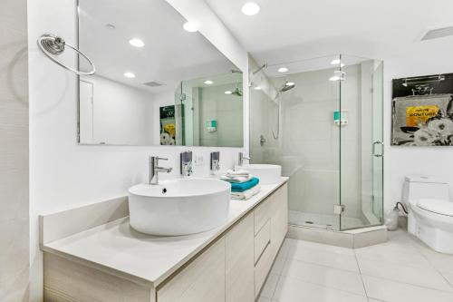 y baño blanco con lavabo y ducha. en Beachwalk Resort #3302 - PENTHOUSE IN THE SKY 3BDR and 3BA LUXURY CONDO DIRECT OCEAN VIEW, en Hallandale Beach