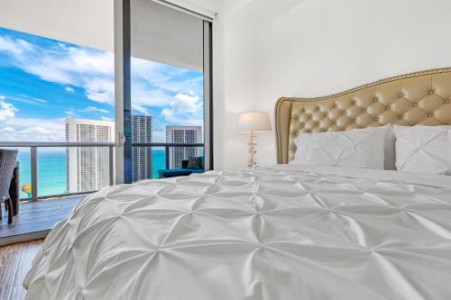 1 dormitorio con 1 cama blanca grande y ventana grande en Beachwalk Resort #3302 - PENTHOUSE IN THE SKY 3BDR and 3BA LUXURY CONDO DIRECT OCEAN VIEW en Hallandale Beach