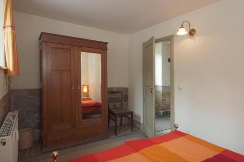 ドレスデンにあるFerienwohnung Villa Haniel Oskarのベッドルーム1室(ベッド1台付)、木製キャビネットが備わります。