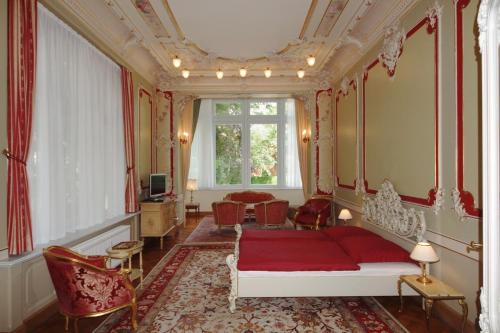 a bedroom with a red bed and a window at Ferienwohnungen Villa Haniel Hugo in Dresden