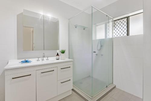 a white bathroom with a shower and a sink at Longbeach Unit 12 in Gold Coast