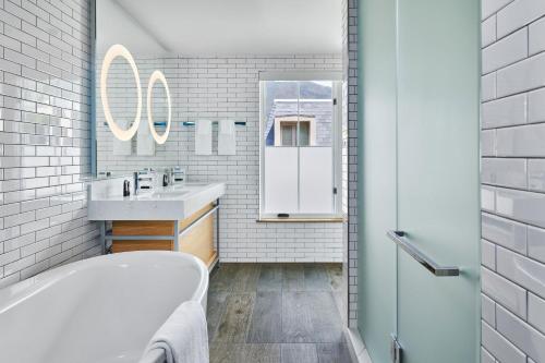 a bathroom with a tub and a sink and a mirror at The Sky Residences at W Aspen in Aspen