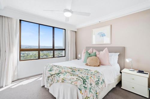 a white bedroom with a bed and a large window at Royal Palms 24 F in Gold Coast