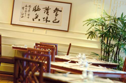 a restaurant with tables and chairs and a picture on the wall at Radisson Collection Hotel, Yangtze Shanghai in Shanghai