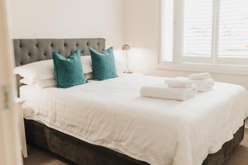 a bedroom with a large white bed with blue pillows at The Mill Apartments Clare Valley in Clare