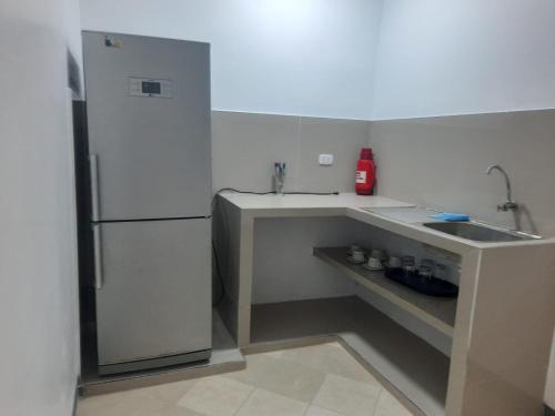 uma pequena cozinha com um lavatório e um frigorífico em Hospedaje Margarita em La Merced