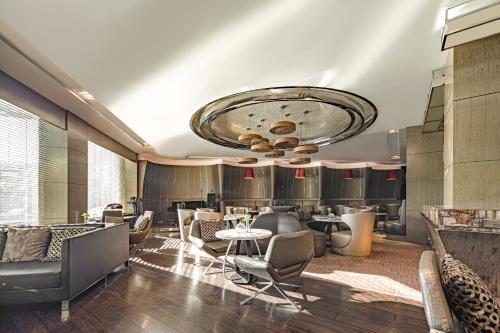 a lobby with chairs and tables and a large ceiling at Radisson Collection Hotel, Yangtze Shanghai in Shanghai