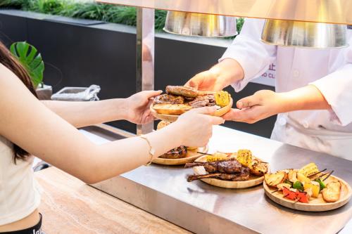 a group of people getting food from a buffet at Radisson Collection Hotel, Yangtze Shanghai in Shanghai