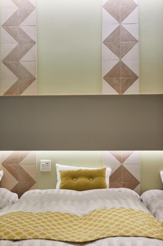 a bedroom with a large bed with a yellow pillow at Hotel TORACO konohana in Osaka