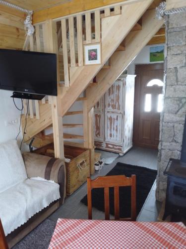 a living room with a staircase with a flat screen tv at Etno Koliba Nikoleta in Žabljak
