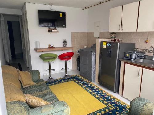 uma sala de estar com um sofá e uma cozinha em Acogedor Apartamento Pequeño e Independiente em Bogotá