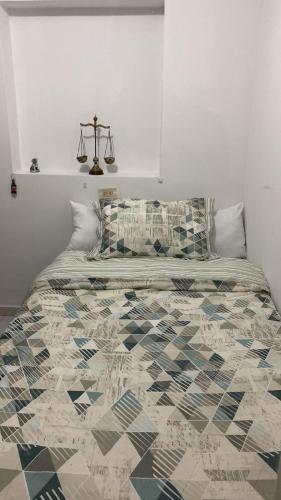 1 dormitorio con 1 cama con edredón en Acogedor Apartamento Pequeño e Independiente, en Bogotá