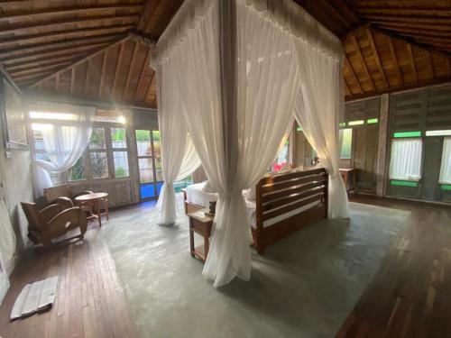 a bedroom with a bed and curtains in a room at Sarini Villas in Blahbatu