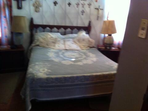 a dog laying on a bed in a bedroom at Las Palmas in Tezoyuca