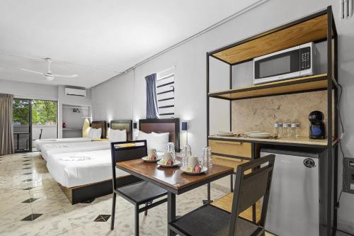 um quarto de hotel com uma cama, uma mesa e um micro-ondas em Suites Reforma by HomiRent em Mérida