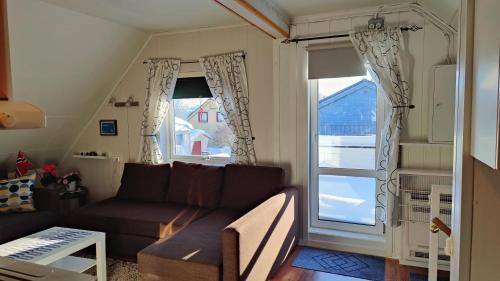 a living room with a couch and a large window at Kirkenes Lodge in Kirkenes