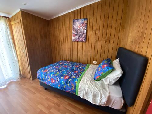 a bedroom with a bed with a colorful comforter at Departamento en Tomé centro in Tomé