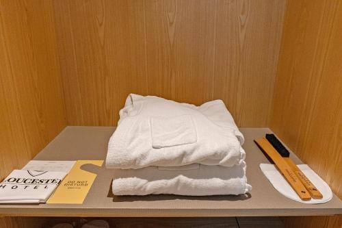 a stack of white towels sitting on a table at Gloucester Hotel Cheongju in Cheongju