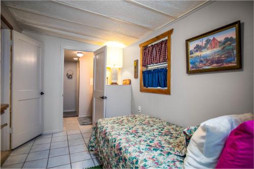a bedroom with a bed and a picture on the wall at Clear River Cabin on Medina in Bandera