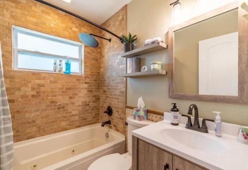 La salle de bains est pourvue d'un lavabo, d'une baignoire et d'un miroir. dans l'établissement Douglas Lake House with Private Hot Tub by Staycating, à Sevierville